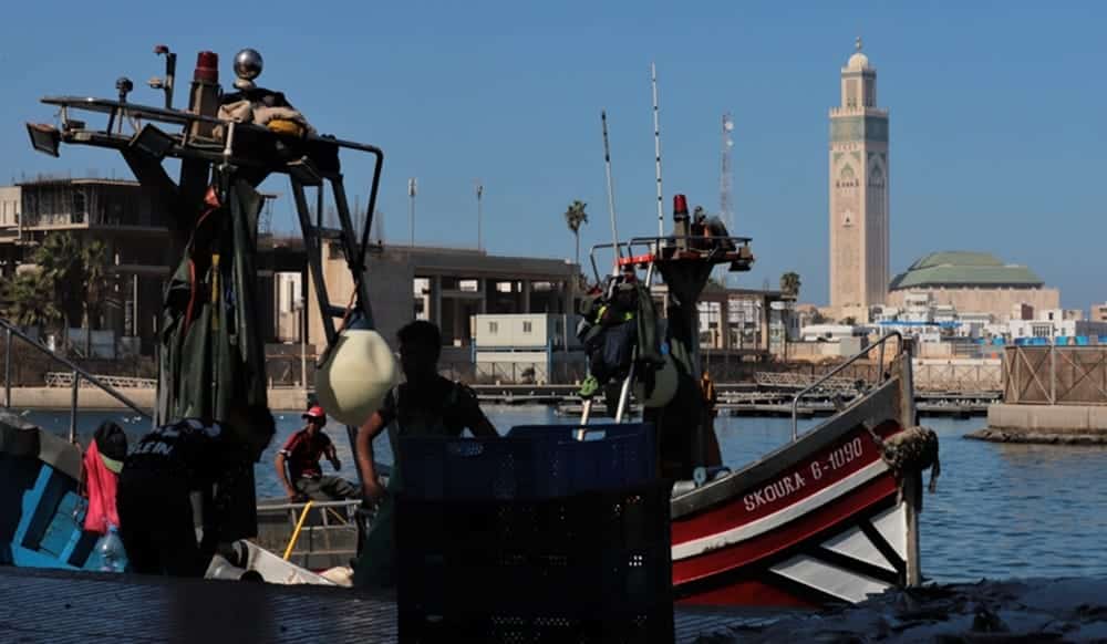 Des pêcheurs déchargent leur cargaison sur un bateau de pêche artisanale amarré au port de Casablanca